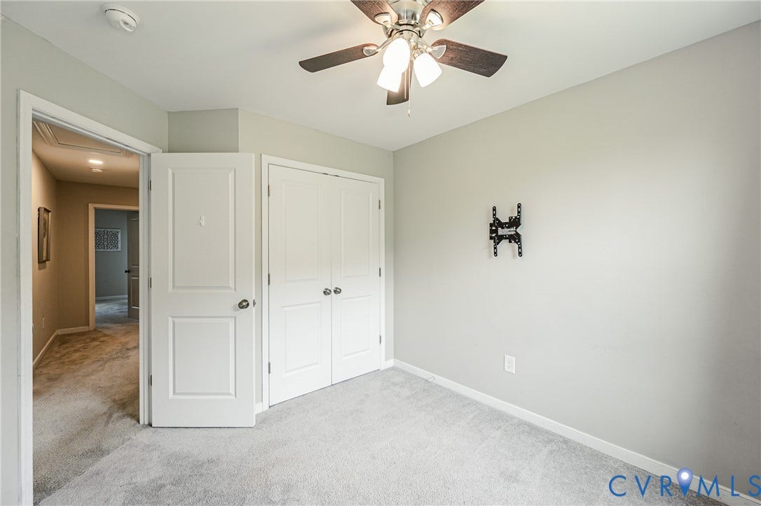 1324 Stone Ridge Park Loop, Henrico, VA 23228 Carpeted room featuring a ceiling fan with integrated lighting, a double-door closet, and a wall-mounted television bracket