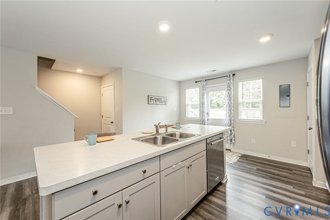 1324 Stone Ridge Park Loop, Henrico, VA 23228 Kitchen island featuring a double-basin stainless steel sink, light-toned countertop, and light gray cabinetry
