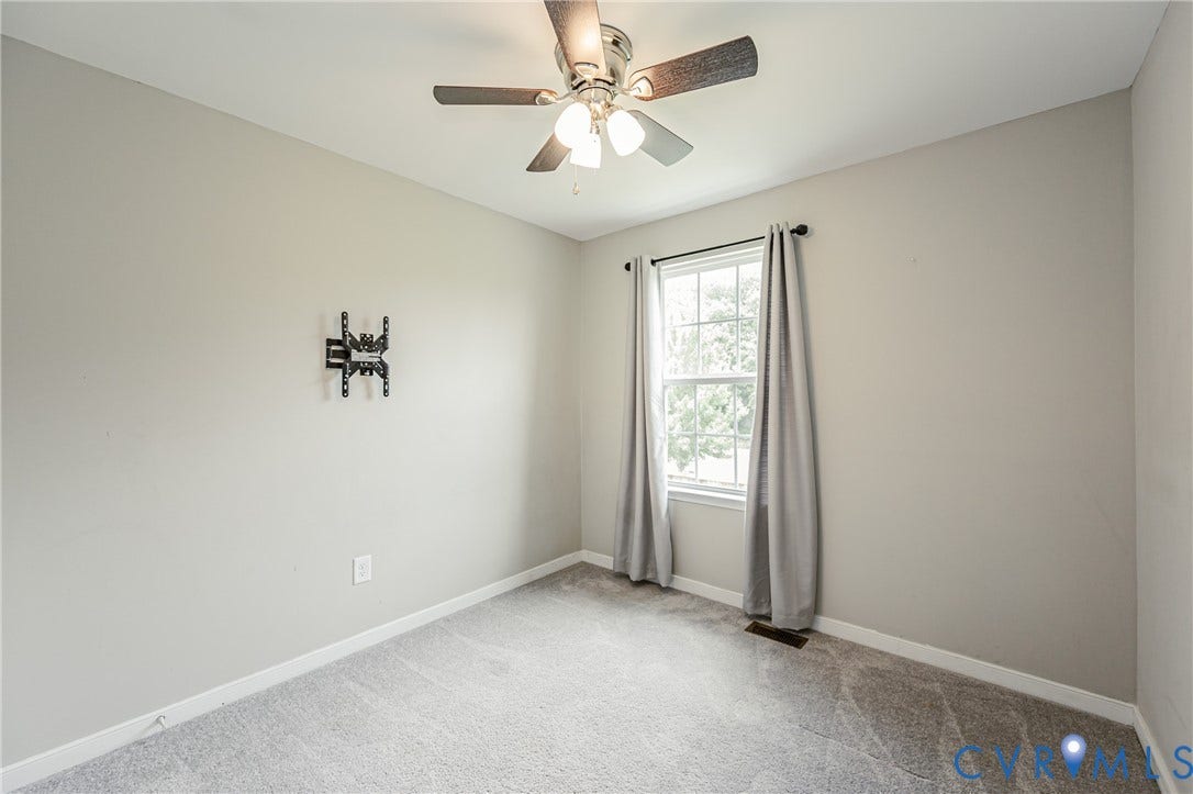 1324 Stone Ridge Park Loop, Henrico, VA 23228 Neutral-toned room featuring a ceiling fan with integrated lighting, a double-hung window with drapery, and soft gray carpet flooring