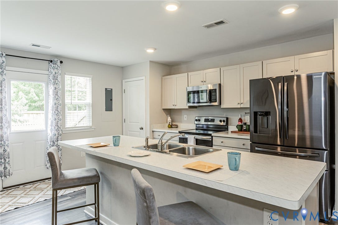 1324 Stone Ridge Park Loop, Henrico, VA 23228 Open-concept kitchen featuring an eat-at island, stainless steel appliances, recessed lighting, and white cabinetry