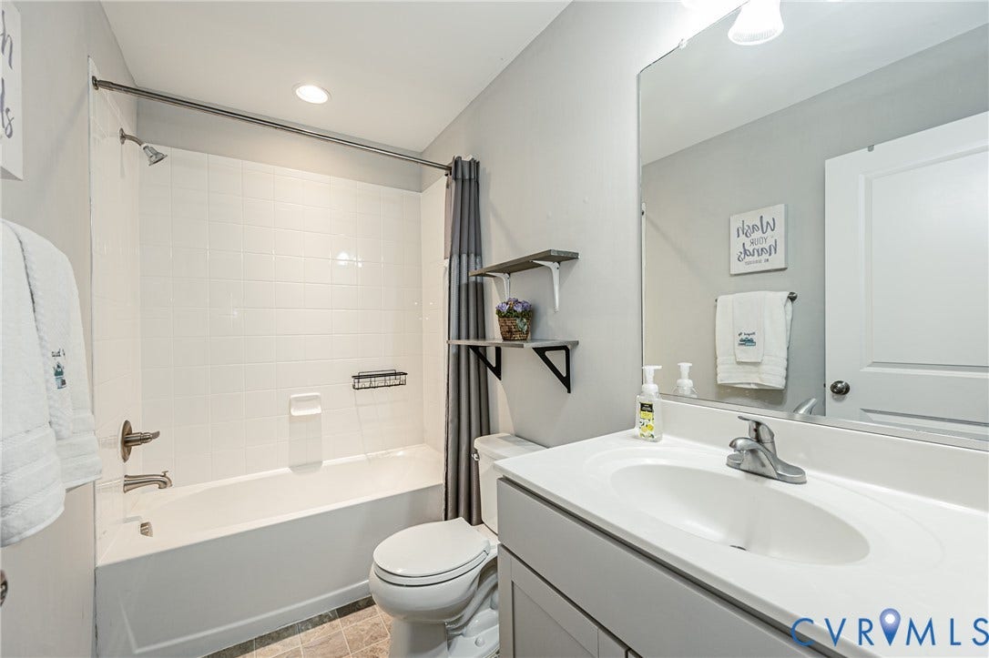 1324 Stone Ridge Park Loop, Henrico, VA 23228 Bathroom featuring a white bathtub with subway tile surround, a built-in shower caddy, and brushed nickel fixtures