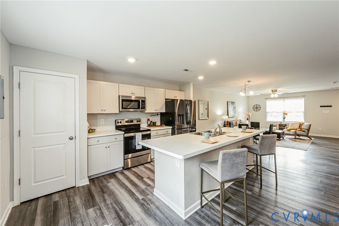 1324 Stone Ridge Park Loop, Henrico, VA 23228 Open-concept kitchen featuring white cabinetry, stainless steel appliances, and wood-finish flooring
