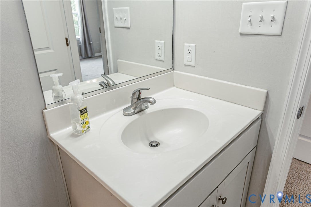 1324 Stone Ridge Park Loop, Henrico, VA 23228 Bathroom vanity with an integrated white sink, brushed nickel faucet, and a large mirror