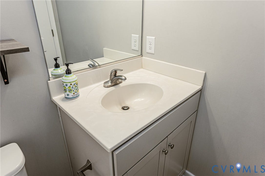 1324 Stone Ridge Park Loop, Henrico, VA 23228 Bathroom vanity featuring a white countertop with an integrated sink, brushed nickel faucet, and a mirror