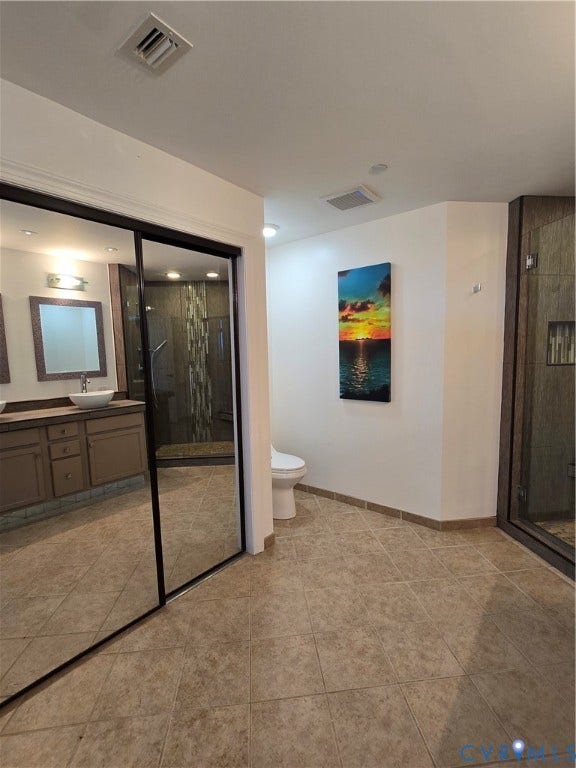 1101 Haxall Point, #815, Richmond, VA 23219 Bathroom featuring neutral-toned tile flooring, a mirrored sliding closet door, and a toilet