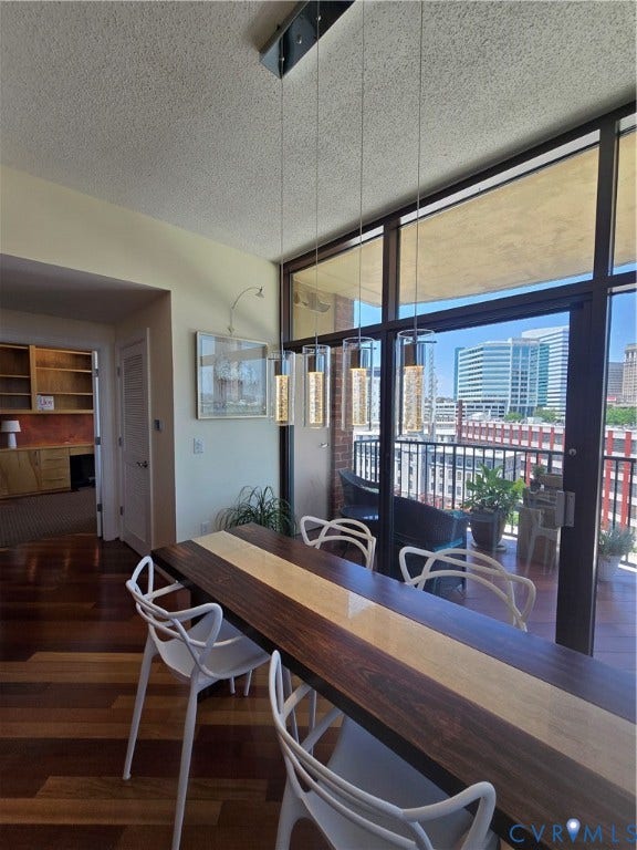 1101 Haxall Point, #815, Richmond, VA 23219 Dining area featuring wood-finish flooring, a contemporary linear chandelier with multiple pendant lights, and floor-to-ceiling windows