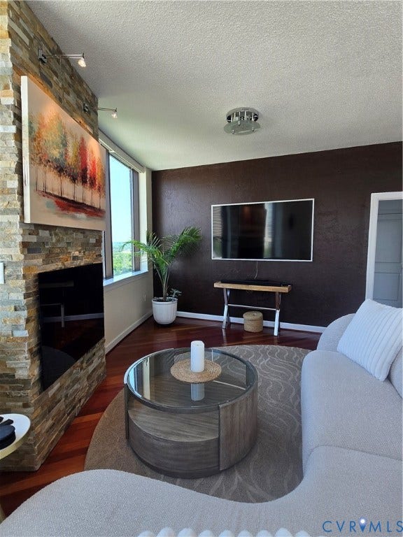 1101 Haxall Point, #815, Richmond, VA 23219 Living area featuring wood-finish flooring, a stacked stone accent wall, and track lighting