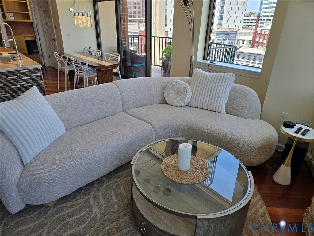 1101 Haxall Point, #815, Richmond, VA 23219 Living area featuring wood-finish flooring, a contemporary curved sectional, and expansive windows