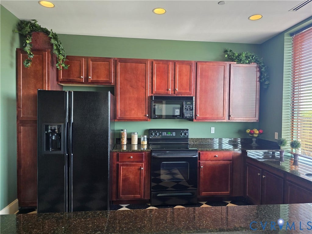 1101 Haxall Point, #815, Richmond, VA 23219 Kitchen featuring rich wood cabinetry, dark speckled countertops, and black appliances including a side-by-side refrigerator with dispenser