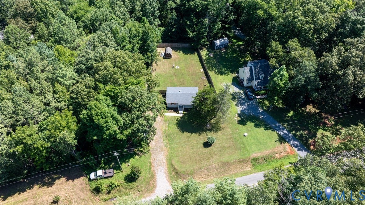 13070 Auburn Mill Road, Glen Allen, VA 23059 Aerial perspective showcasing a property surrounded by mature trees, featuring a main residence with a gray roof, a separate outbuilding, and a gravel driveway