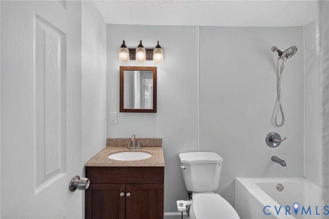 13070 Auburn Mill Road, Glen Allen, VA 23059 Bathroom vanity featuring a granite-finish countertop, undermount sink, and dark wood cabinetry