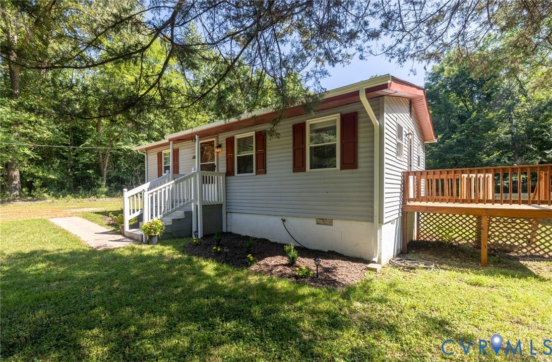 13070 Auburn Mill Road, Glen Allen, VA 23059 Light gray siding with red shutters and trim, featuring a front porch with white railings, a concrete walkway, and a side deck with wood railings and lattice skirting