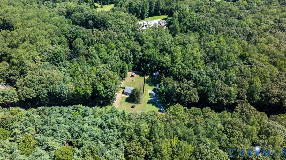 13070 Auburn Mill Road, Glen Allen, VA 23059 Aerial perspective showcasing a property surrounded by mature trees, featuring a light-colored structure with a dark roof and a perimeter fence