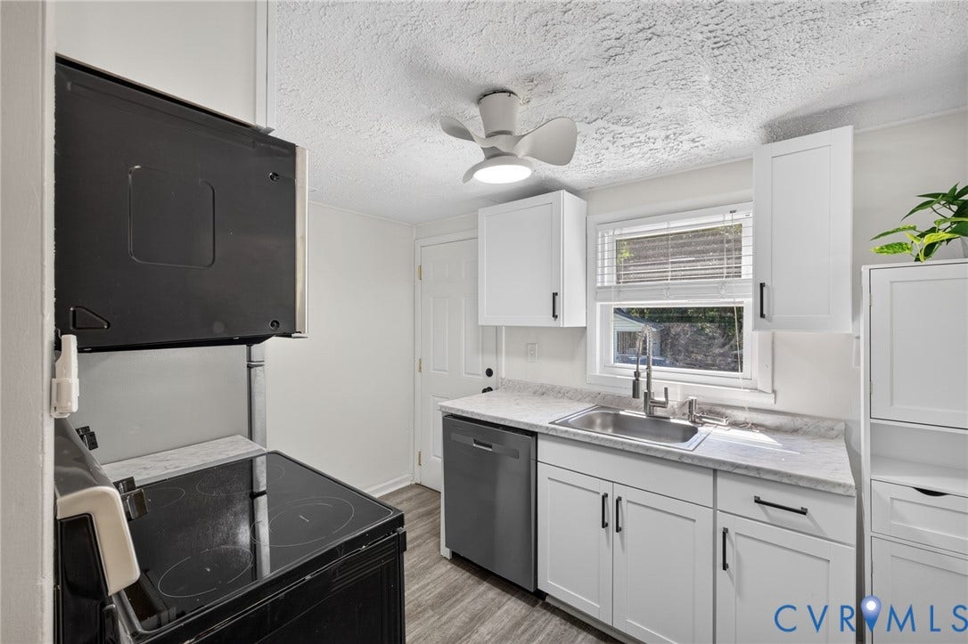 13070 Auburn Mill Road, Glen Allen, VA 23059 Modern kitchen featuring white shaker cabinetry, stainless steel sink with gooseneck faucet, light-colored countertops, and wood-finish flooring