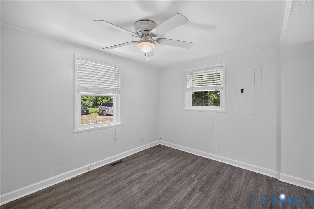 13070 Auburn Mill Road, Glen Allen, VA 23059 Neutral-toned room featuring two windows with white blinds, wood-finish flooring, a ceiling fan with light fixture, and white baseboards
