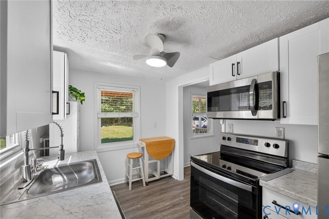 13070 Auburn Mill Road, Glen Allen, VA 23059 Kitchen featuring white cabinetry, stainless steel appliances, wood-finish flooring, a stainless steel sink with a gooseneck faucet, and light-toned countertops
