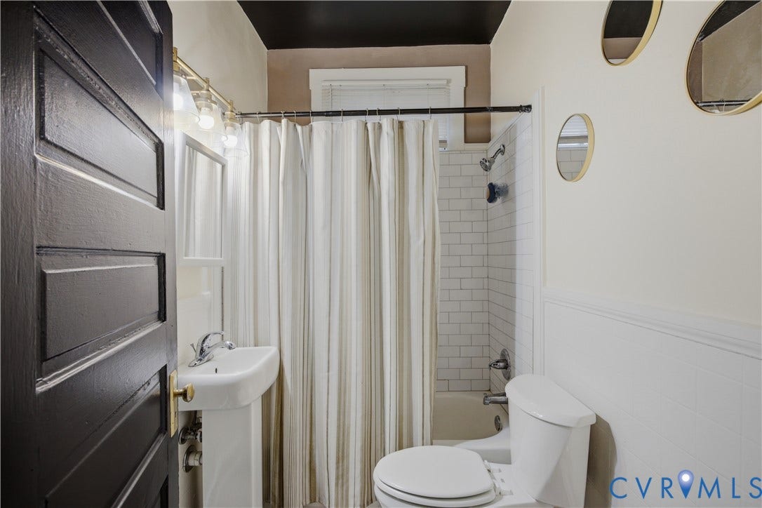 1615 N 19th Street, Richmond, VA 23223 Bathroom with a pedestal sink, white subway tile shower surround, and a paneled lower wall