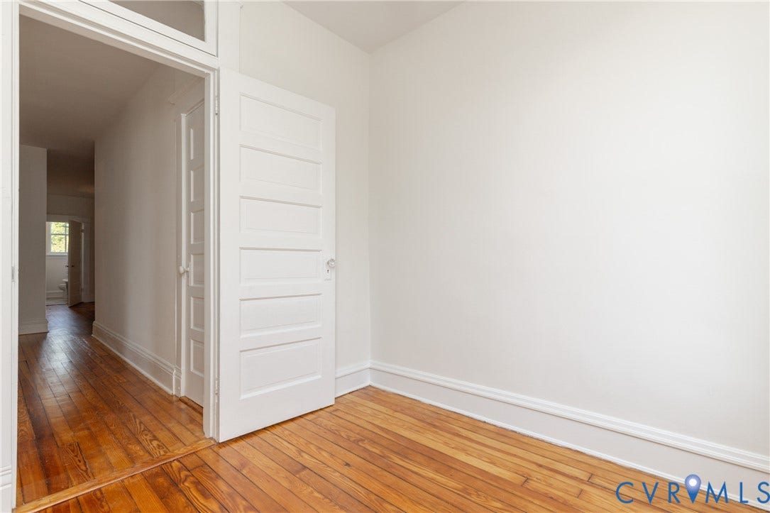 3135 Floyd Avenue, Museum District, Richmond, VA 23221 Room featuring wood-finish flooring, white walls, white baseboards, and a five-panel interior door