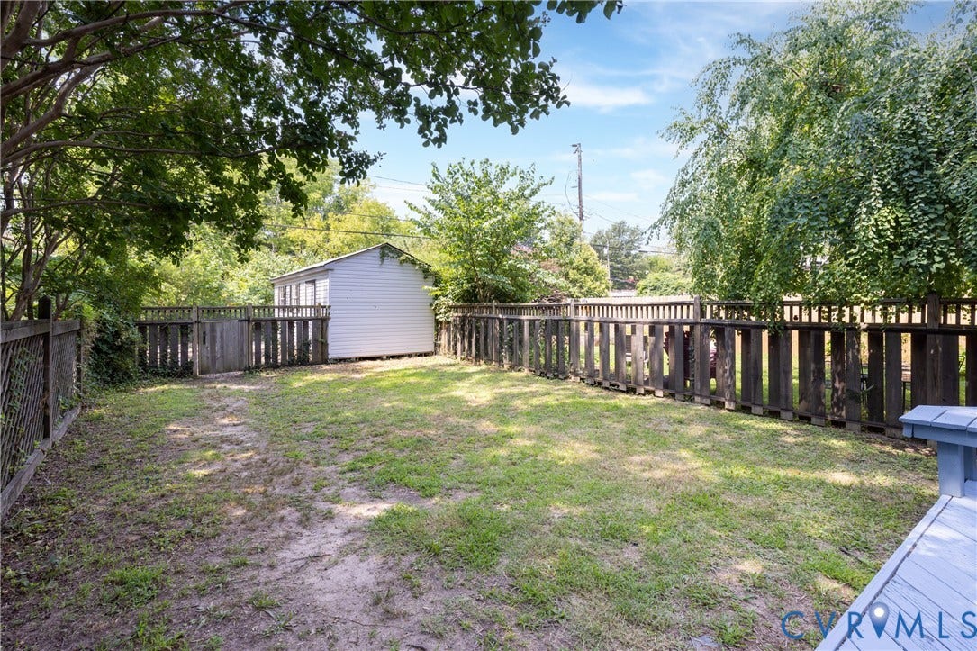 3135 Floyd Avenue, Museum District, Richmond, VA 23221 Expansive backyard featuring a white storage shed, mature trees, and a wooden privacy fence