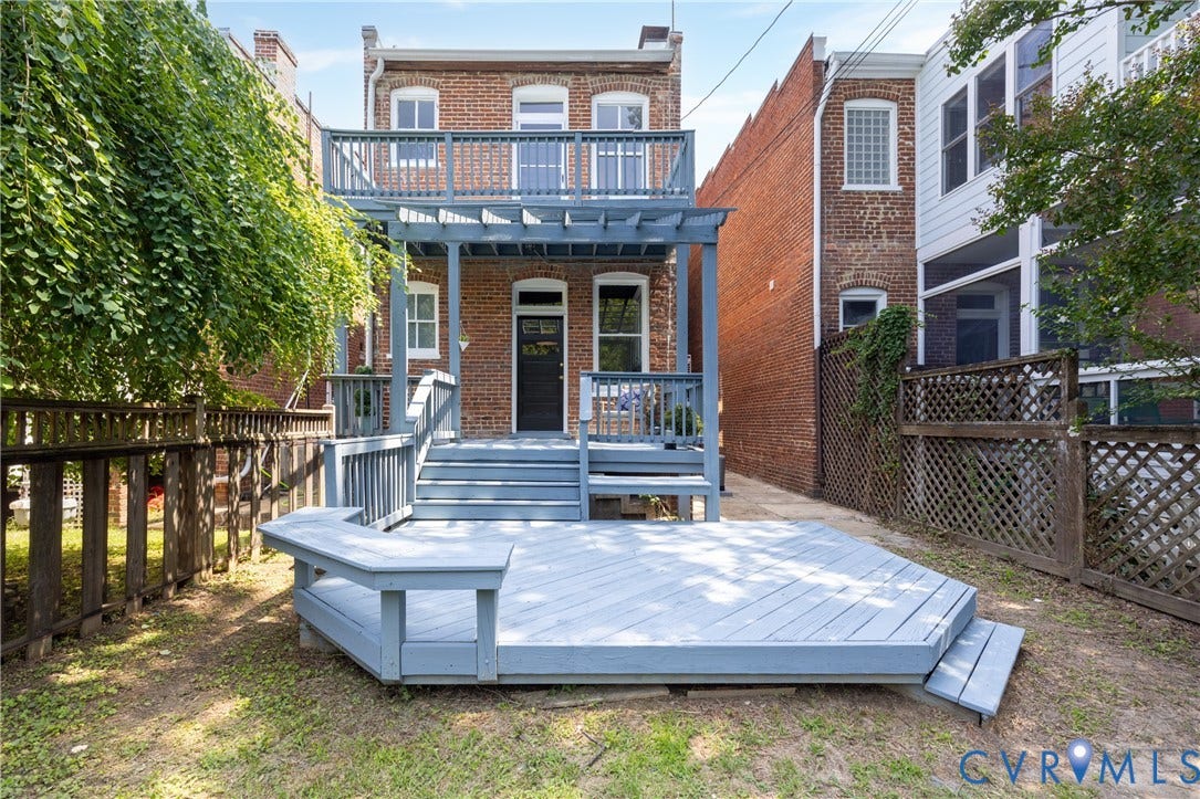 3135 Floyd Avenue, Museum District, Richmond, VA 23221 Rear brick facade featuring a two-story deck with a pergola, ground-level hexagonal deck, and a fenced yard