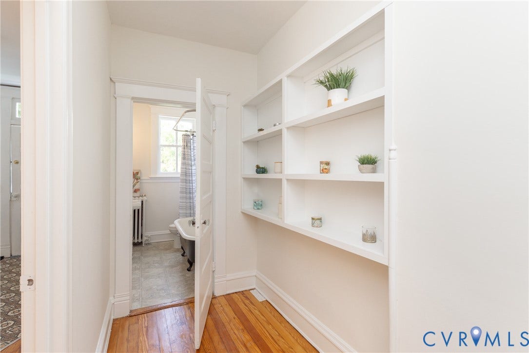 3135 Floyd Avenue, Museum District, Richmond, VA 23221 Hallway featuring built-in shelving, hardwood flooring, and a doorway to a bathroom with a clawfoot tub