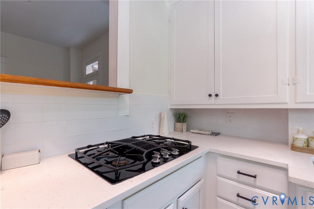3135 Floyd Avenue, Museum District, Richmond, VA 23221 Kitchen featuring a built-in black gas cooktop, white shaker cabinetry with dark hardware, a white subway tile backsplash, and light-colored countertops