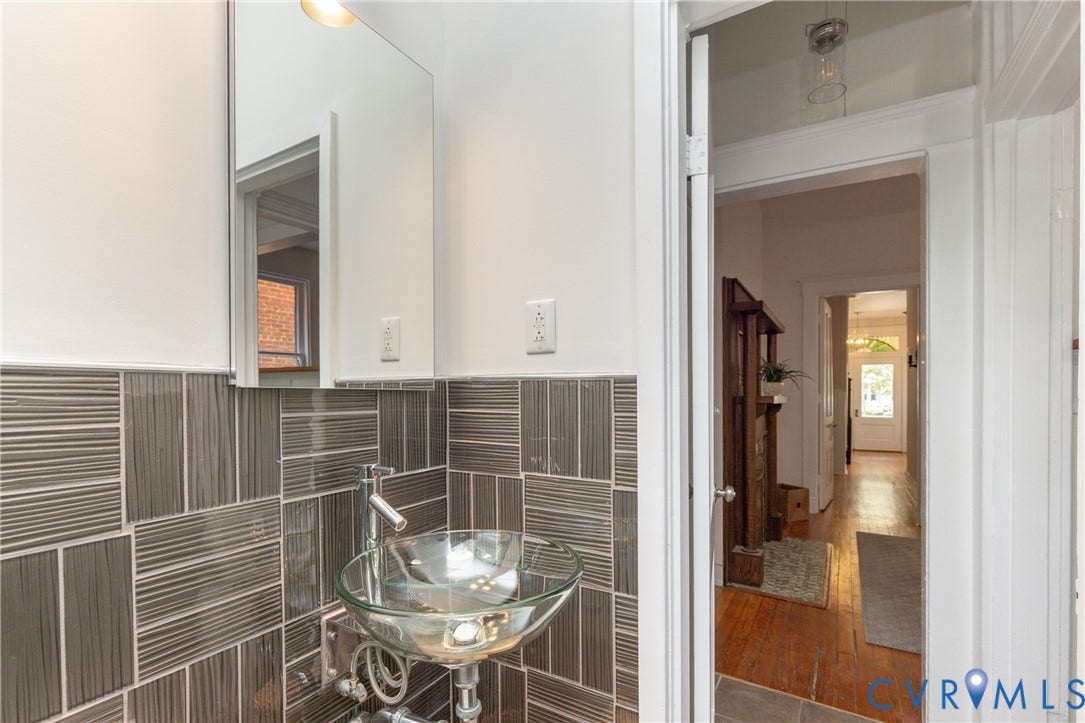 3135 Floyd Avenue, Museum District, Richmond, VA 23221 Bathroom vanity featuring a glass vessel sink, chrome faucet, white medicine cabinet, and textured grey tile backsplash