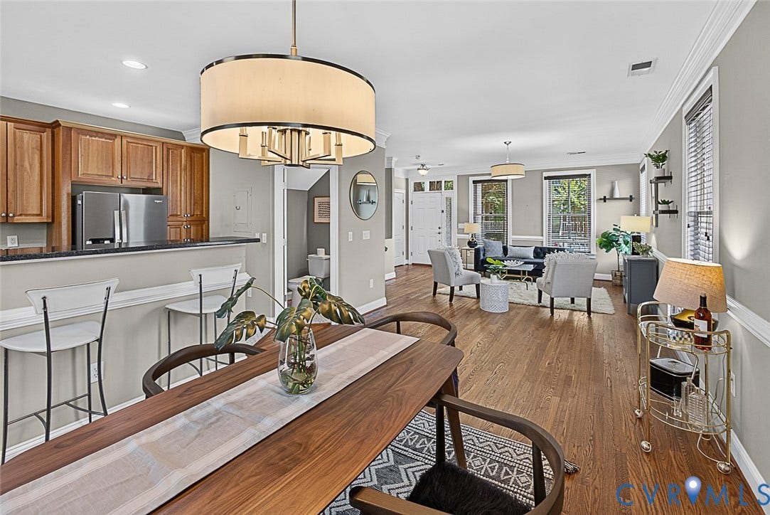 710 S Laurel Street, Oregon Hill, Richmond, VA 23220 Open-concept living space featuring wood-finish flooring, a kitchen bar with seating, stainless steel appliances, and a drum-style chandelier