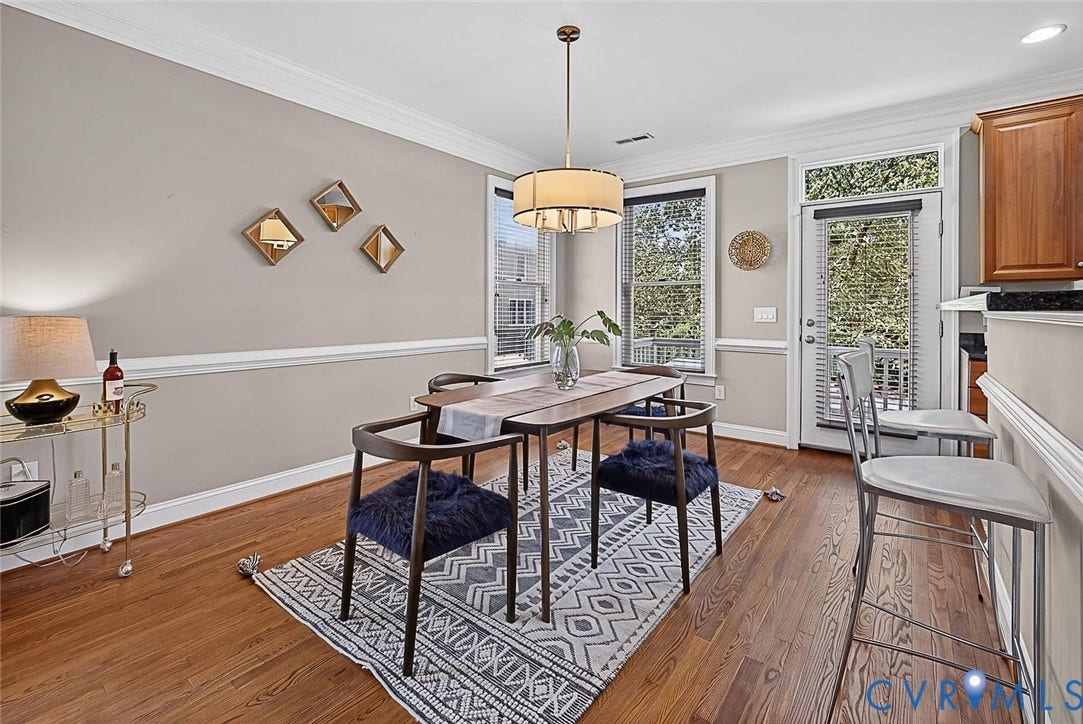 710 S Laurel Street, Oregon Hill, Richmond, VA 23220 Dining area featuring wood-finish flooring, crown molding, a built-in breakfast bar, a modern chandelier, and two windows with blinds