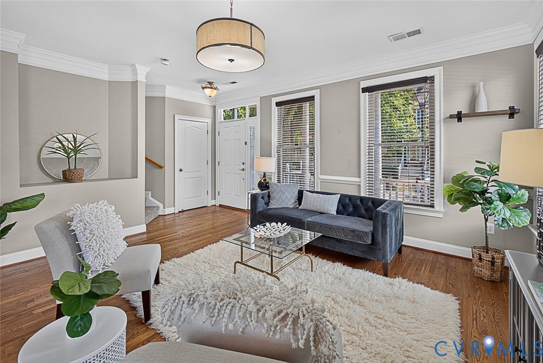 710 S Laurel Street, Oregon Hill, Richmond, VA 23220 Bright living space featuring wood-finish flooring, white crown molding, two large windows with blinds, a prominent entryway, and a contemporary ceiling light fixture