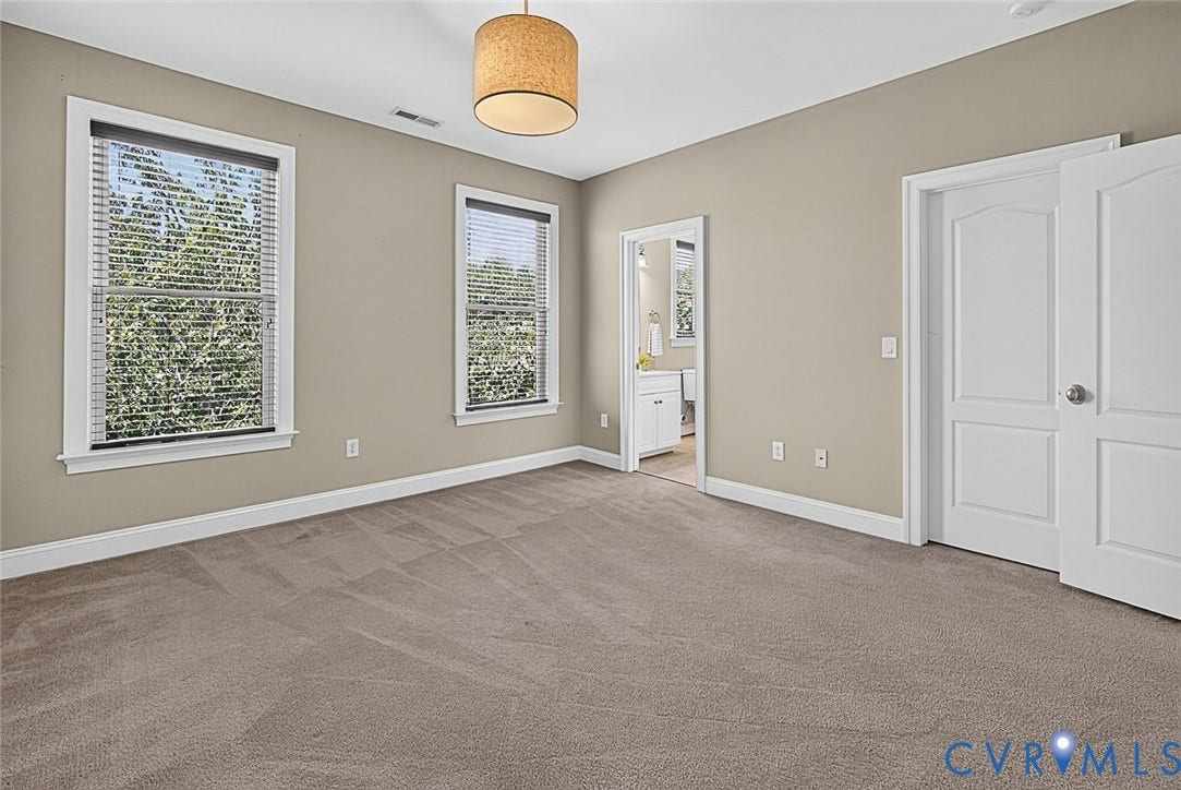 710 S Laurel Street, Oregon Hill, Richmond, VA 23220 Carpeted room featuring two large windows with blinds, a drum-style pendant light fixture, a wide entry to a bathroom with vanity, and a two-panel interior door