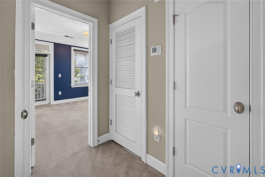710 S Laurel Street, Oregon Hill, Richmond, VA 23220 Interior doorway opening to a room featuring blue accent walls, light-colored carpeting, and a ceiling-mounted light fixture