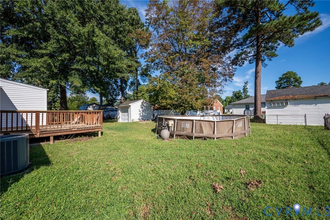 912 Williamsburg Road, Colonial Manor, Colonial Heights, VA 23834 Expansive yard featuring a wood deck, above-ground pool, and mature trees