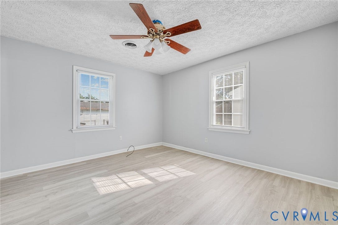 912 Williamsburg Road, Colonial Manor, Colonial Heights, VA 23834 Wood-finish flooring, two windows with white trim, and a ceiling fan with light fixture