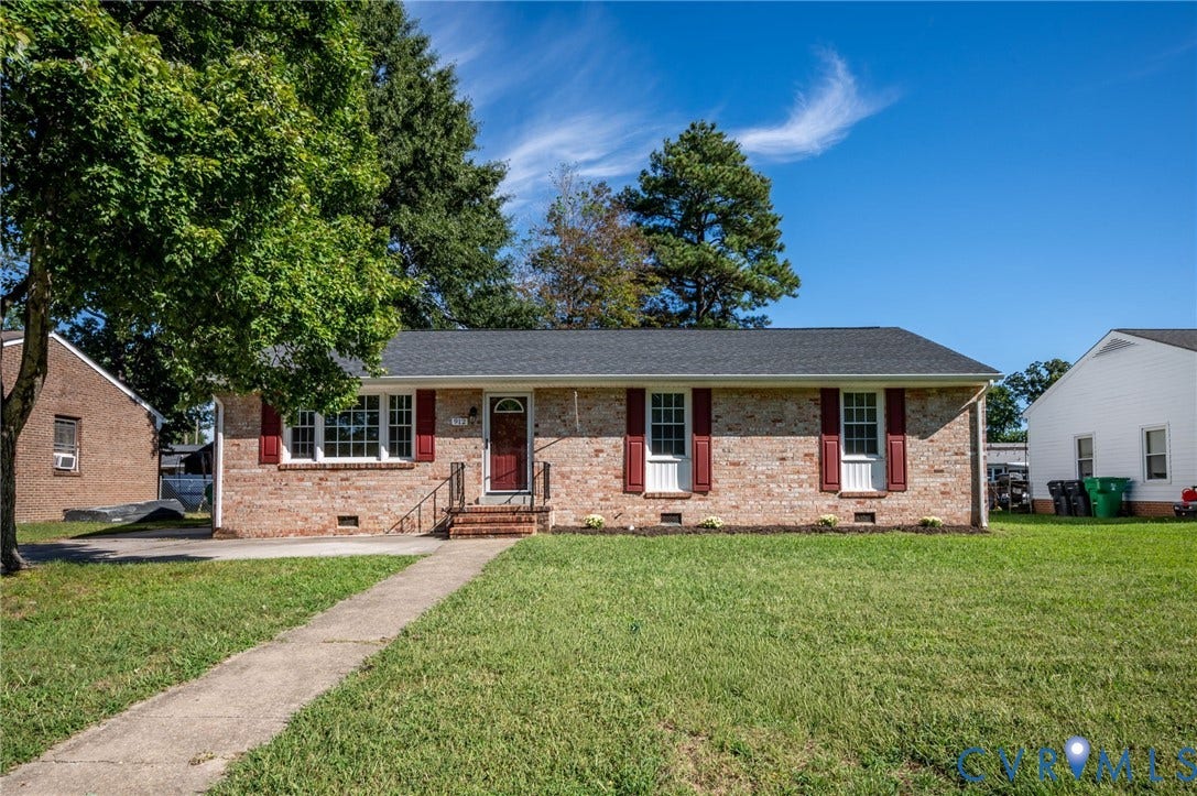 912 Williamsburg Road, Colonial Manor, Colonial Heights, VA 23834 Brick exterior featuring a dark-toned roof, red shutters, and a front entry with a red door