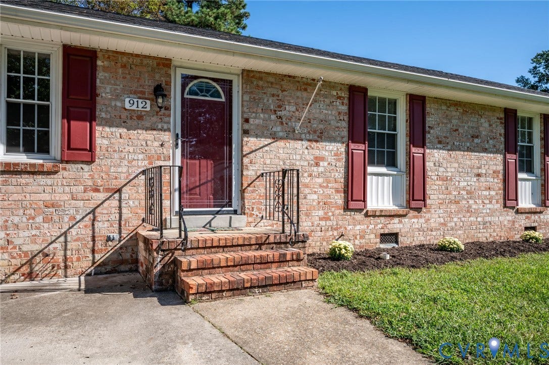 912 Williamsburg Road, Colonial Manor, Colonial Heights, VA 23834 Brick exterior with red shutters, a red front door, and a traditional brick stoop with wrought iron railings