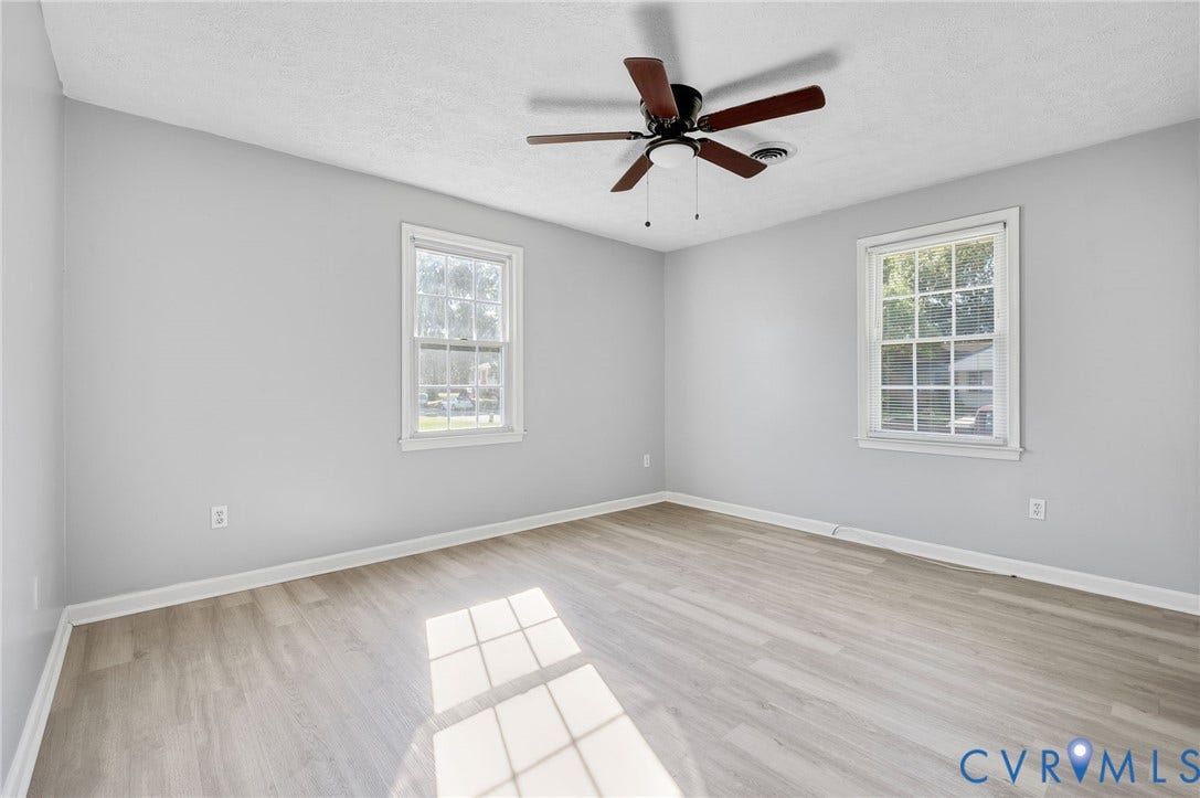 912 Williamsburg Road, Colonial Manor, Colonial Heights, VA 23834 Wood-finish flooring with light gray walls, two windows, and a ceiling fan with integrated lighting