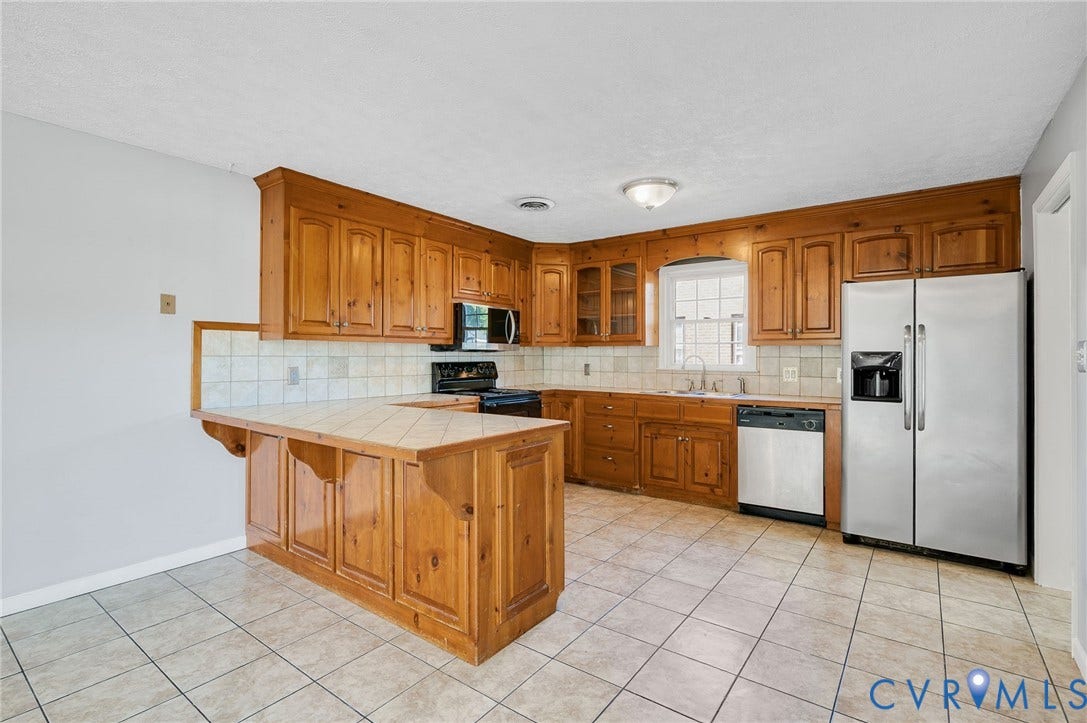 912 Williamsburg Road, Colonial Manor, Colonial Heights, VA 23834 Kitchen featuring wood cabinetry, tile flooring, tile countertops, a tile backsplash, and stainless steel appliances