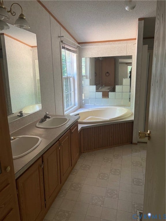 Bathroom featuring a dual vanity with light wood cabinetry, an integrated corner bathtub, patterned floor tile, and a window with blinds