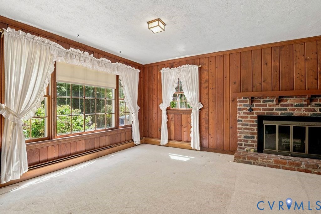 2425 Chancellor Road, North Chesterfield, VA 23235 Wood paneling throughout, brick fireplace with a metal insert, large multi-pane windows, and wall-to-wall carpeting