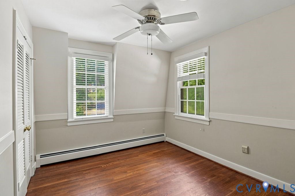2425 Chancellor Road, North Chesterfield, VA 23235 2nd Floor Bedroom #2. Hardwood flooring, multiple windows, ceiling fan, and baseboard heating
