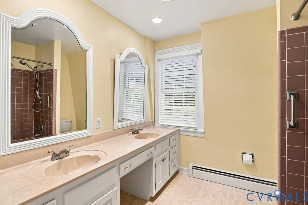 2425 Chancellor Road, North Chesterfield, VA 23235 2nd Floor Primary Bathroom. Dual vanity with integrated sinks, white cabinetry, and decorative framed mirrors