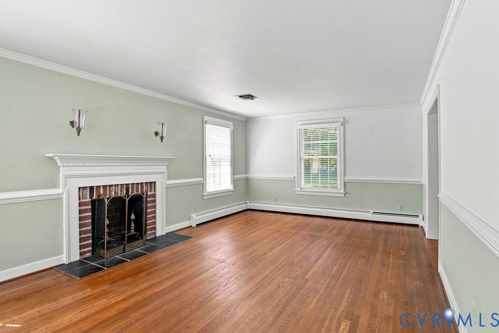2425 Chancellor Road, North Chesterfield, VA 23235 Hardwood flooring throughout, brick fireplace with decorative mantel, two windows with blinds, and crown molding