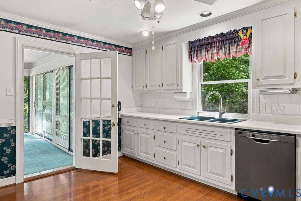 2425 Chancellor Road, North Chesterfield, VA 23235 Wood-finish flooring, white cabinetry, a double basin sink with a gooseneck faucet, a stainless steel dishwasher, and a glass-paned door