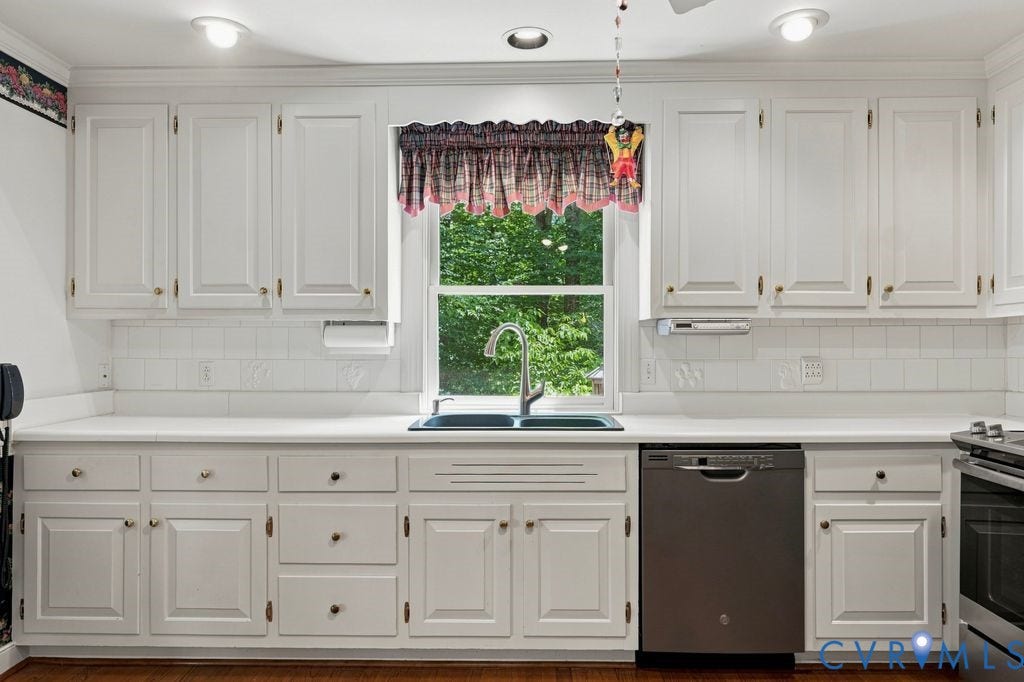 2425 Chancellor Road, North Chesterfield, VA 23235 White cabinetry with gold-tone hardware, undermount double-basin sink, stainless steel dishwasher, white countertop, and white subway tile backsplash
