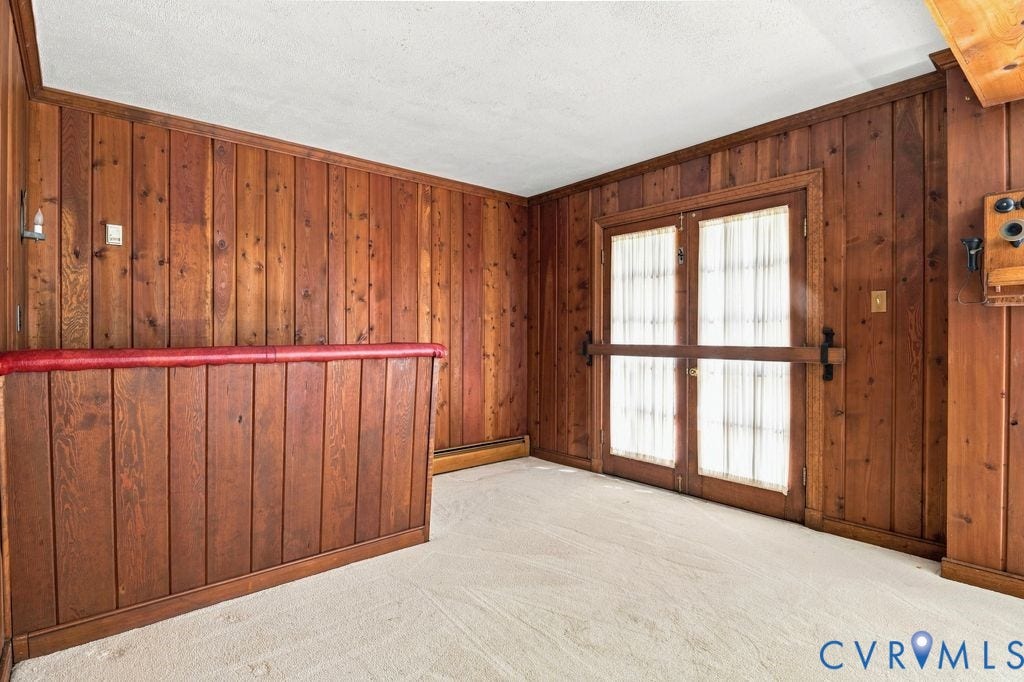 2425 Chancellor Road, North Chesterfield, VA 23235 Basement Wet Bar. Wood-paneled walls, light-toned carpeting, and a double entry door with privacy sheers
