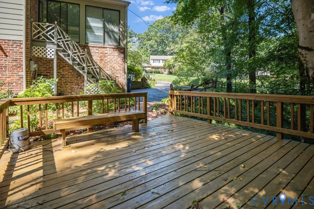 2425 Chancellor Road, North Chesterfield, VA 23235 Expansive wood deck with a built-in bench, wood railing, and surrounding mature trees