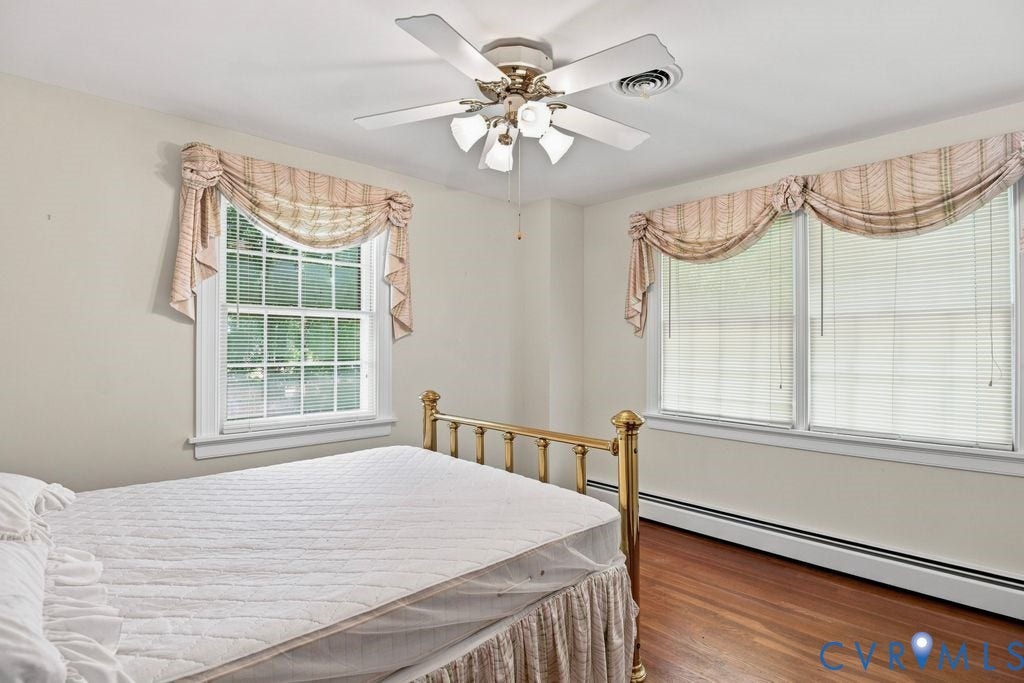 2425 Chancellor Road, North Chesterfield, VA 23235 2nd Floor Bedroom #1. Hardwood flooring, multiple windows, ceiling fan, and baseboard heating
