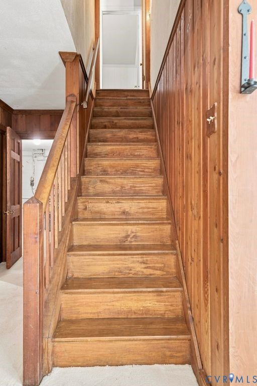 2425 Chancellor Road, North Chesterfield, VA 23235 Wood-finish staircase to basement with solid wood treads, wood paneling, and a wood handrail