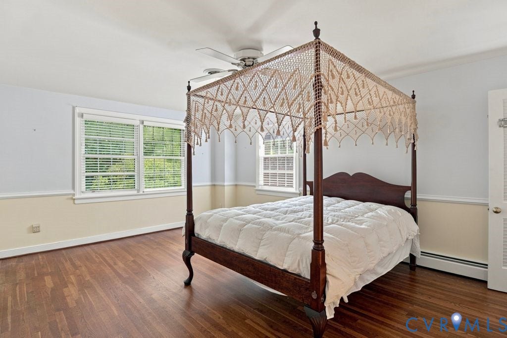 2425 Chancellor Road, North Chesterfield, VA 23235 2nd Floor Primary Bedroom. Hardwood flooring, dual windows with blinds, ceiling fan, bi-fold door, and chair rail molding
